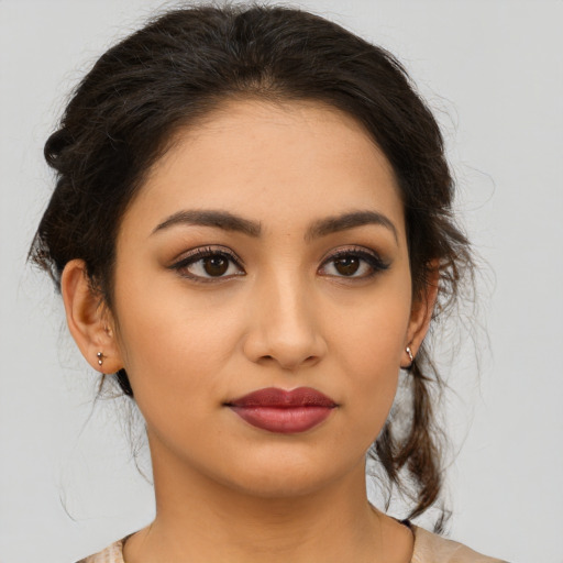 Joyful latino young-adult female with medium  brown hair and brown eyes
