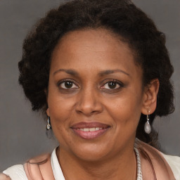 Joyful black adult female with medium  brown hair and brown eyes