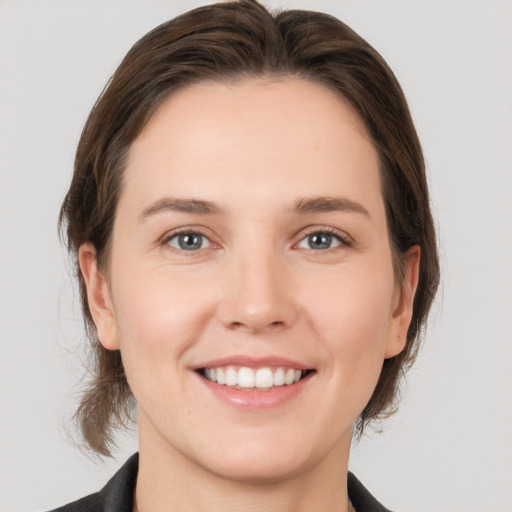 Joyful white young-adult female with medium  brown hair and grey eyes