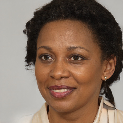 Joyful black adult female with short  brown hair and brown eyes