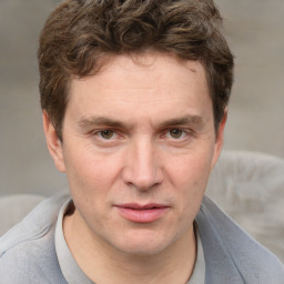 Joyful white adult male with short  brown hair and grey eyes