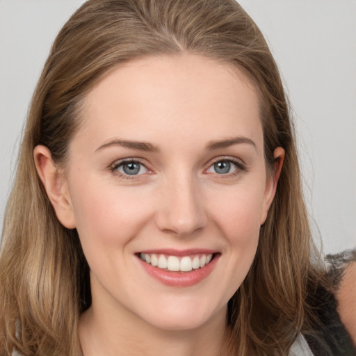 Joyful white young-adult female with long  brown hair and grey eyes