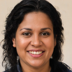 Joyful latino young-adult female with long  brown hair and brown eyes