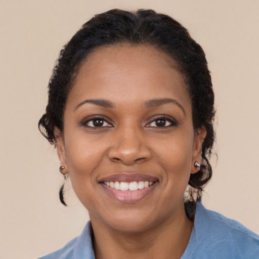 Joyful black young-adult female with long  brown hair and brown eyes