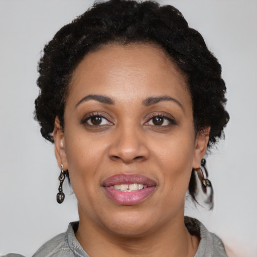 Joyful black adult female with short  brown hair and brown eyes