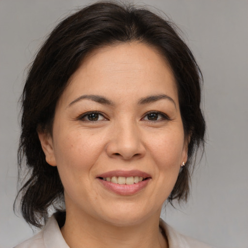 Joyful asian adult female with medium  brown hair and brown eyes