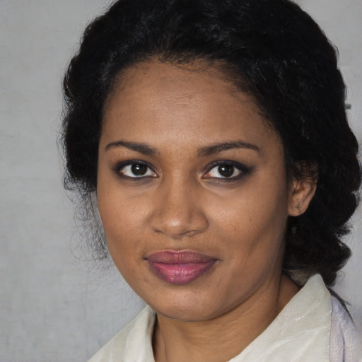 Joyful black adult female with long  black hair and brown eyes