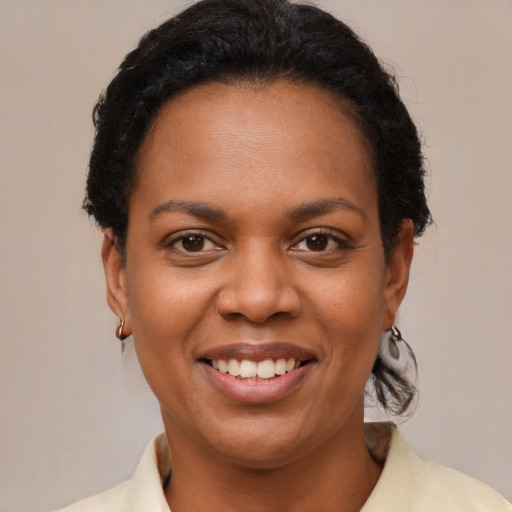 Joyful black young-adult female with short  brown hair and brown eyes
