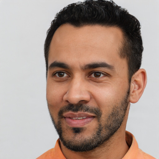 Joyful latino young-adult male with short  black hair and brown eyes
