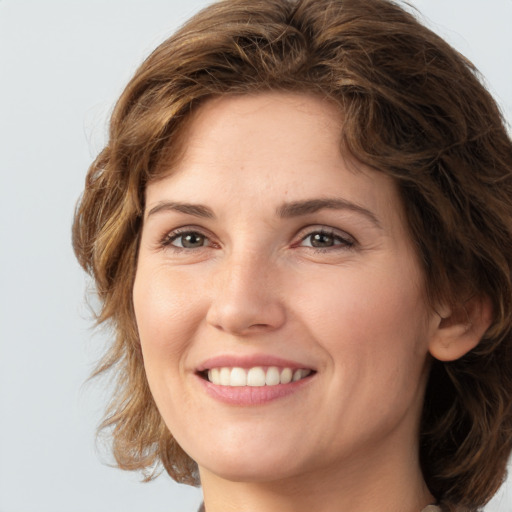 Joyful white young-adult female with medium  brown hair and green eyes