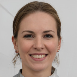 Joyful white young-adult female with medium  brown hair and grey eyes