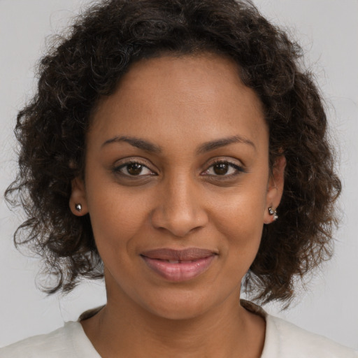 Joyful black young-adult female with medium  brown hair and brown eyes