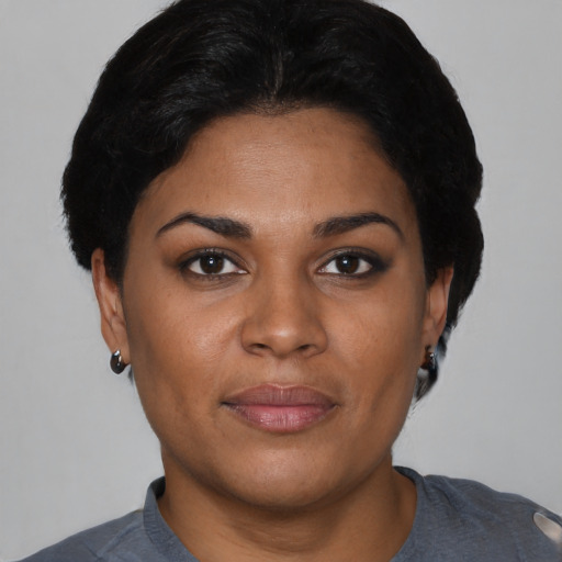Joyful black young-adult female with short  black hair and brown eyes