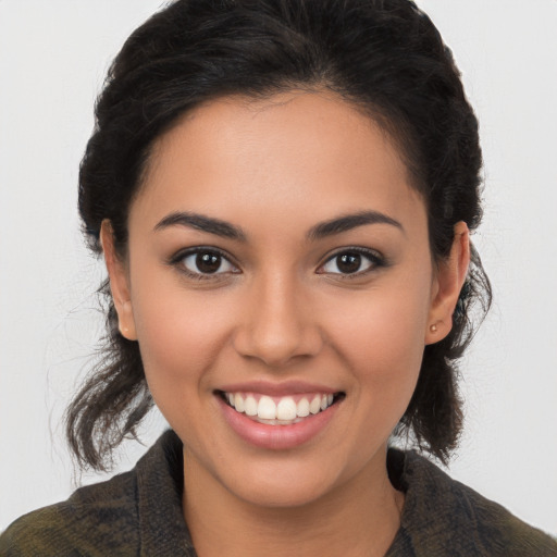 Joyful latino young-adult female with long  brown hair and brown eyes