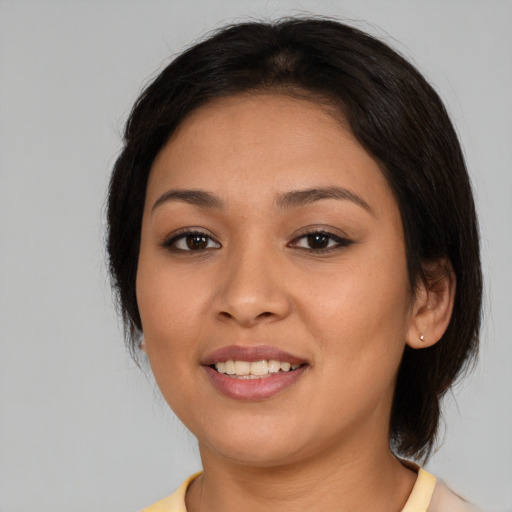 Joyful latino young-adult female with medium  brown hair and brown eyes