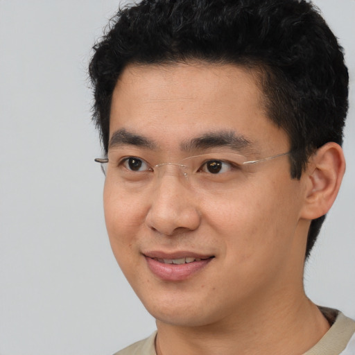 Joyful asian young-adult male with short  brown hair and brown eyes