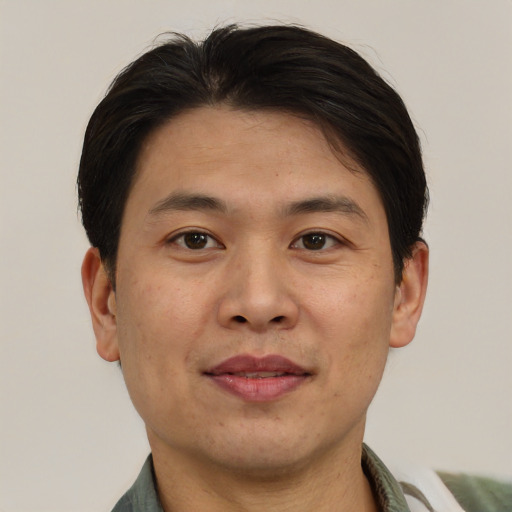 Joyful asian adult male with short  brown hair and brown eyes