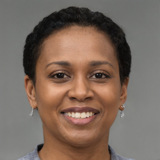 Joyful black adult female with short  brown hair and brown eyes