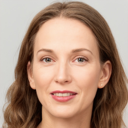 Joyful white adult female with long  brown hair and grey eyes