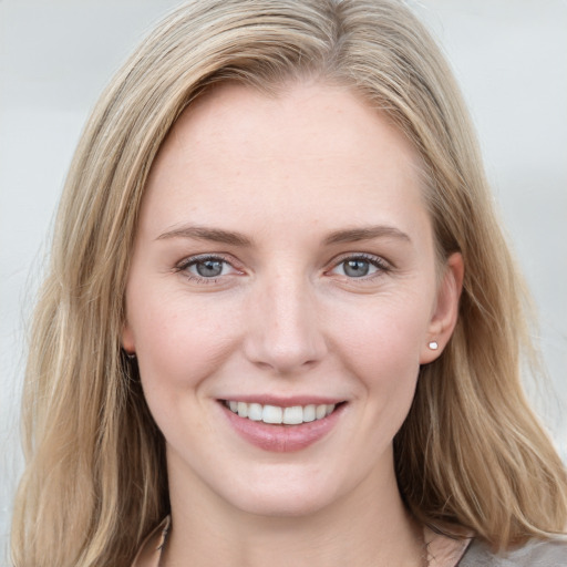 Joyful white young-adult female with long  brown hair and blue eyes