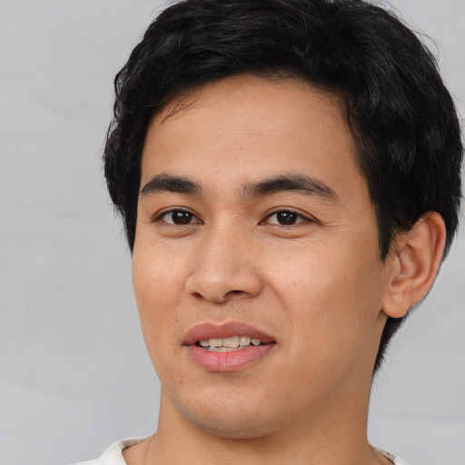 Joyful asian young-adult male with short  black hair and brown eyes