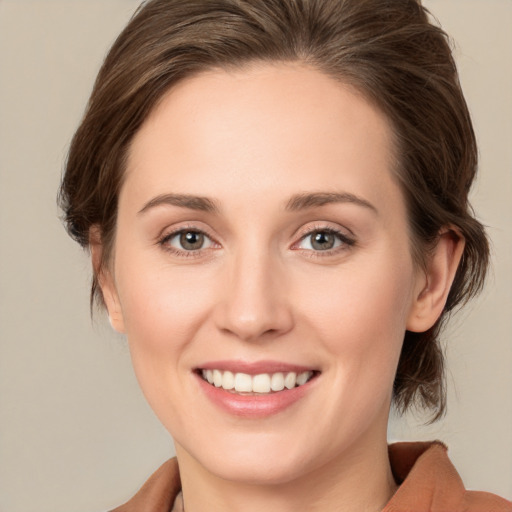 Joyful white young-adult female with medium  brown hair and green eyes