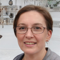 Joyful white adult female with medium  brown hair and blue eyes