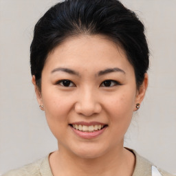 Joyful asian young-adult female with short  brown hair and brown eyes