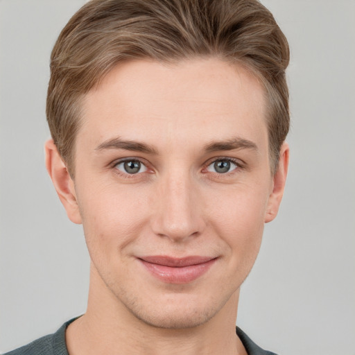 Joyful white young-adult male with short  brown hair and grey eyes