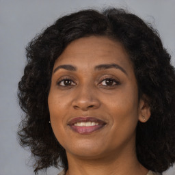 Joyful black adult female with long  brown hair and brown eyes