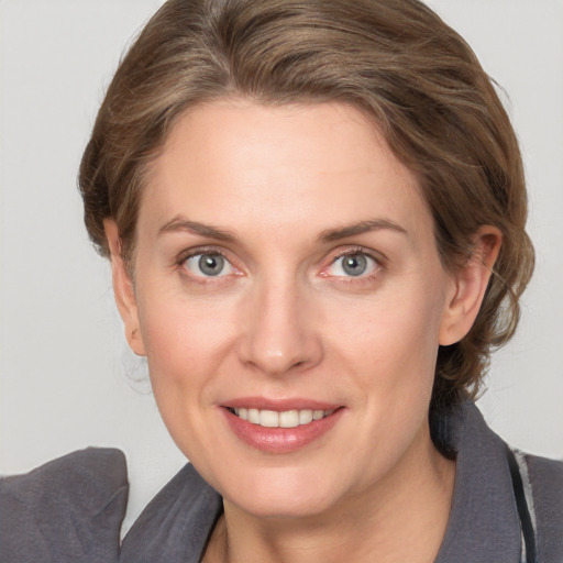 Joyful white young-adult female with medium  brown hair and grey eyes