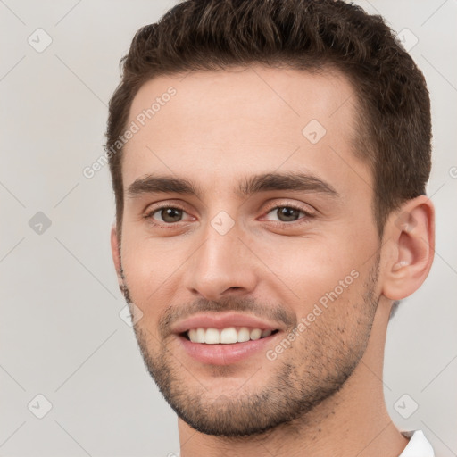 Joyful white young-adult male with short  brown hair and brown eyes