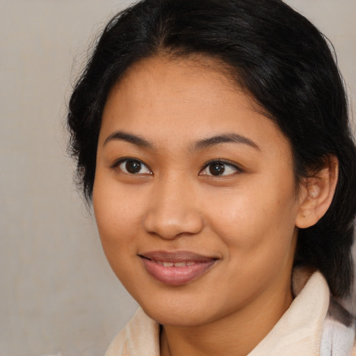 Joyful latino young-adult female with medium  brown hair and brown eyes