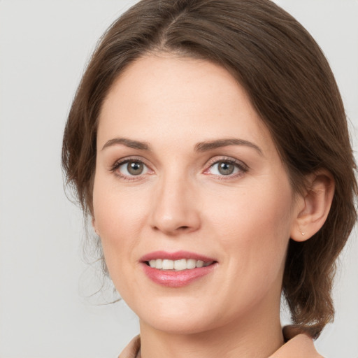 Joyful white young-adult female with medium  brown hair and grey eyes