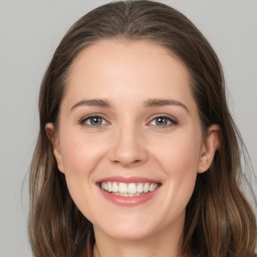 Joyful white young-adult female with long  brown hair and grey eyes