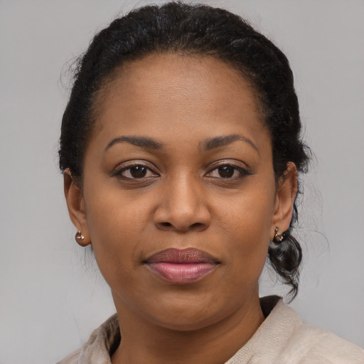 Joyful black adult female with medium  brown hair and brown eyes