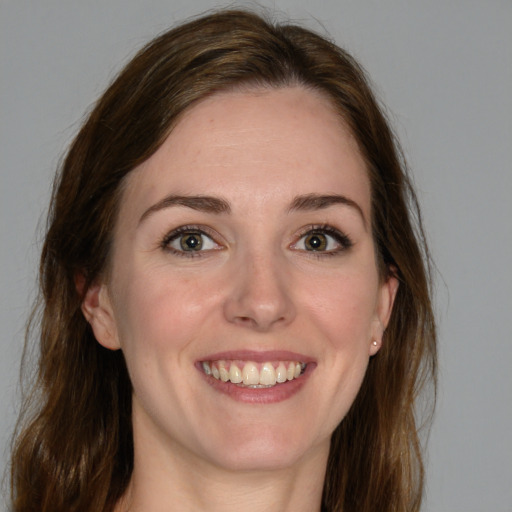 Joyful white young-adult female with medium  brown hair and green eyes