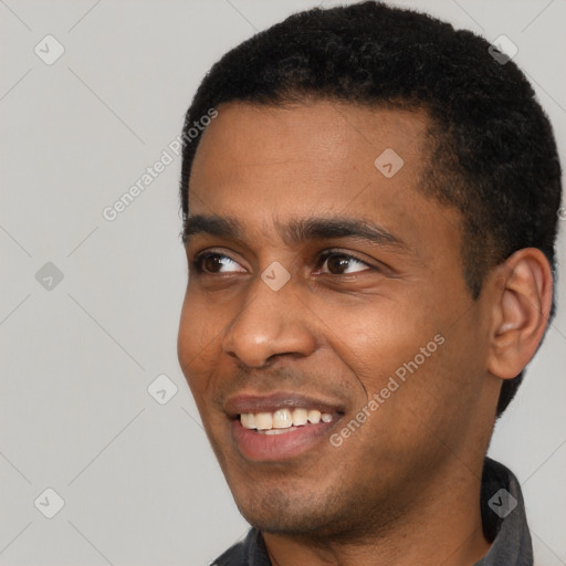 Joyful black young-adult male with short  black hair and brown eyes