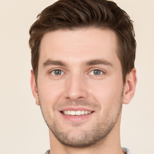 Joyful white young-adult male with short  brown hair and grey eyes