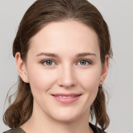 Joyful white young-adult female with medium  brown hair and grey eyes