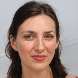 Joyful white adult female with long  brown hair and brown eyes