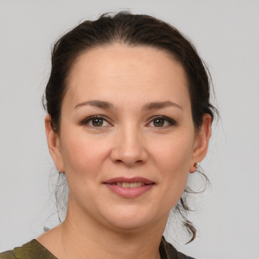 Joyful white young-adult female with medium  brown hair and grey eyes