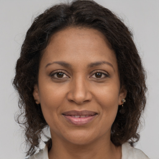Joyful black adult female with medium  brown hair and brown eyes