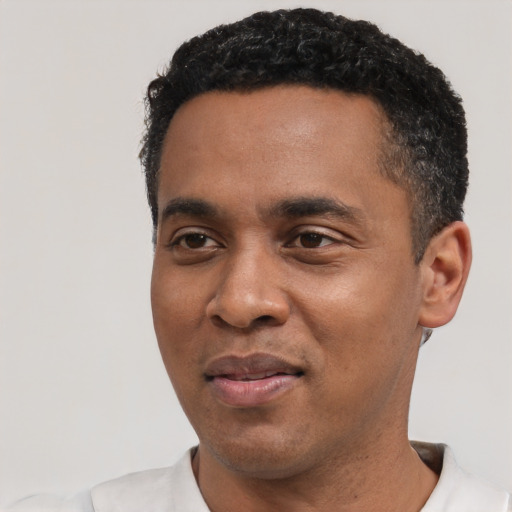 Joyful black young-adult male with short  black hair and brown eyes