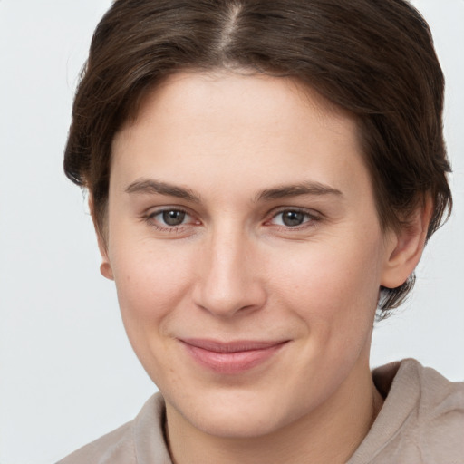 Joyful white young-adult female with short  brown hair and grey eyes