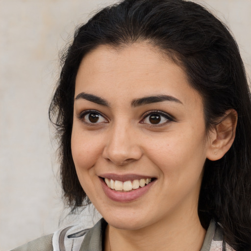 Joyful latino young-adult female with medium  brown hair and brown eyes