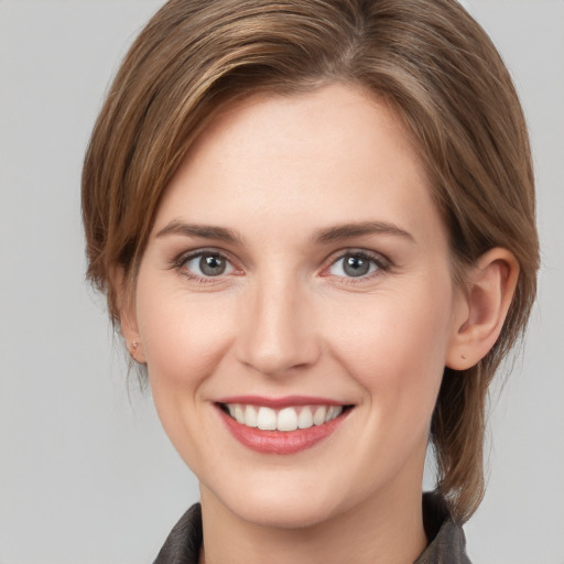 Joyful white young-adult female with medium  brown hair and grey eyes