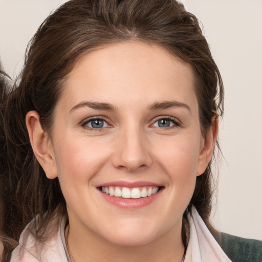 Joyful white young-adult female with medium  brown hair and grey eyes