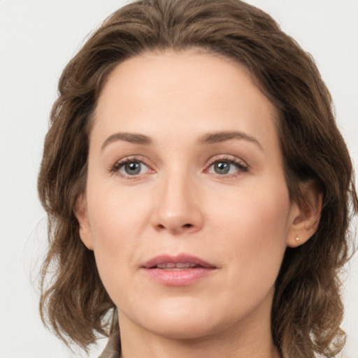 Joyful white young-adult female with medium  brown hair and green eyes