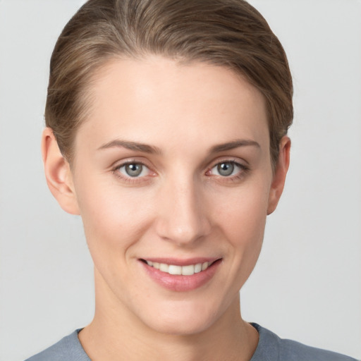 Joyful white young-adult female with short  brown hair and grey eyes